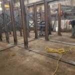 Welding activity and steel rack frames in a fabrication area. View 2 of 5