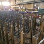 Welding activity and steel rack frames in a fabrication area. View 4 of 5