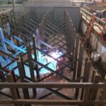 Welding activity and steel rack frames in a fabrication area. View 5 of 5