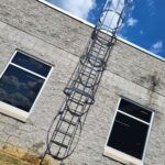 Exterior caged vertical ladder on an industrial wall