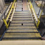 Multiple views along a sloped industrial conveyor with yellow side structure. View 1 of 4