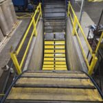 Multiple views along a sloped industrial conveyor with yellow side structure. View 4 of 4
