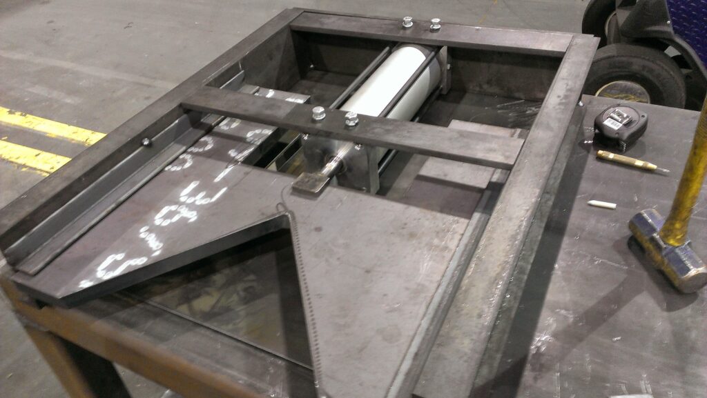 Raw steel frame and fitted components on a work surface