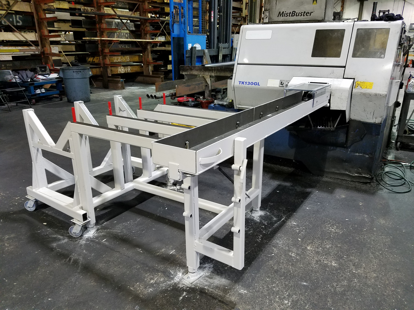 NMS-built saw table installed beside an industrial saw.