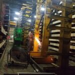 Active industrial rack repair work along a rack row