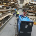 Long industrial rack aisle with work at lower framing