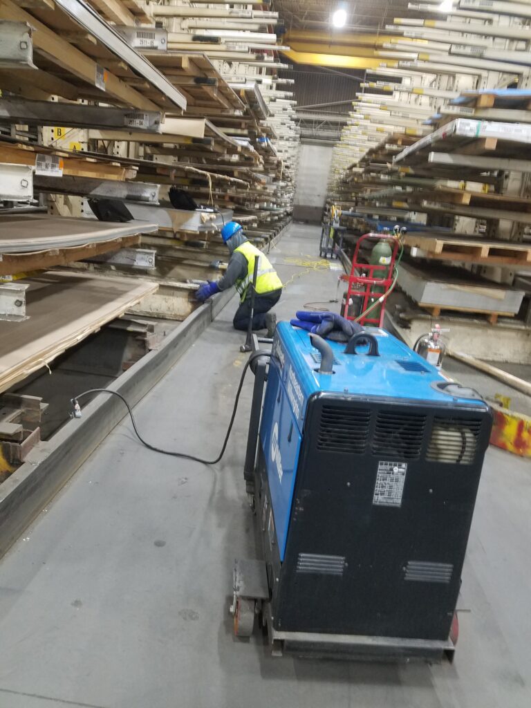 Long industrial rack aisle with work at lower framing