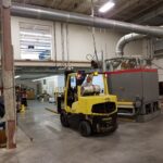 Fabric-line equipment being moved by forklift during relocation